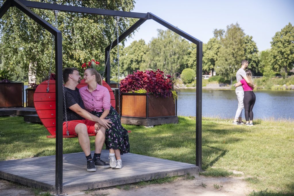 Pariskunta rakkauspuiston sydänkeinussa